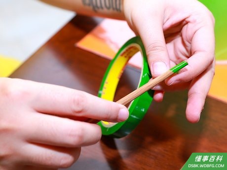 Step 4 用绿色花带贴将木串包好，然后将它插到泡沫球的中央位置。