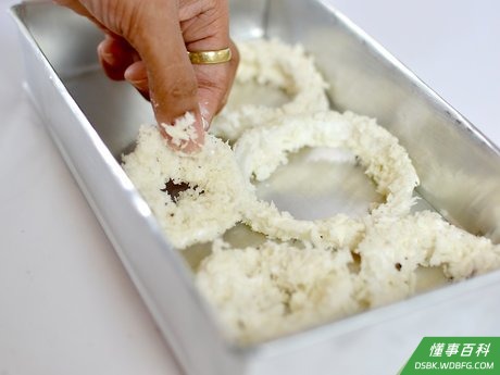 Step 7 将蘸取了面糊的洋葱圈单层摆放在铺有羊皮纸的烤盘上。